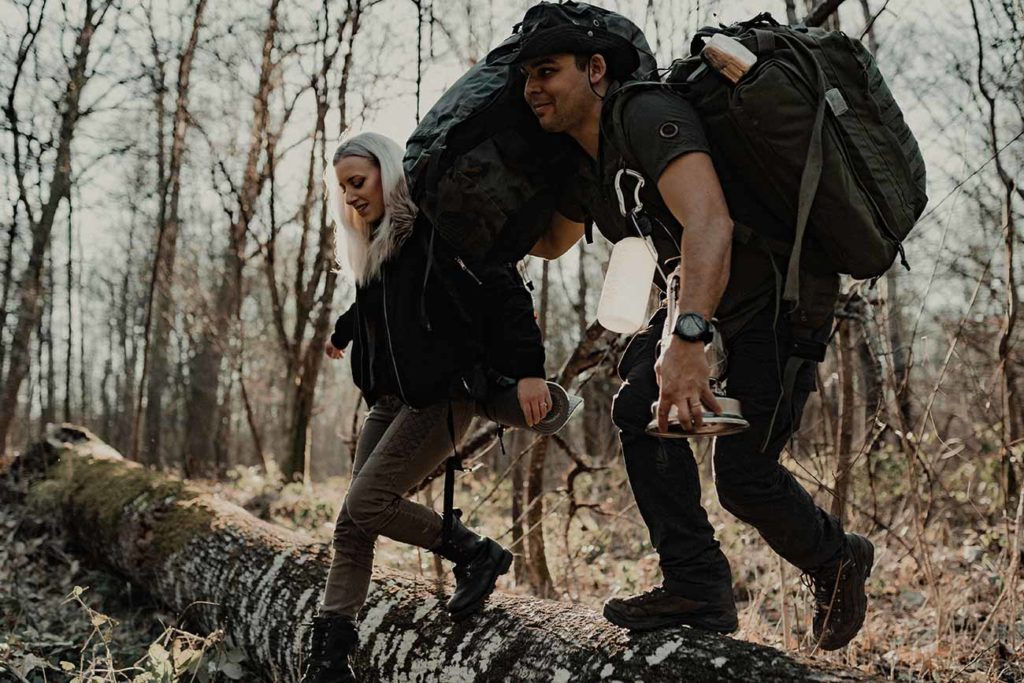 Anaïs et Romain enjambe un tronc d'arbre mort.
