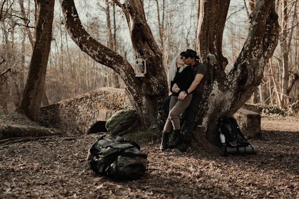 Un couple s'embrasse dans la forêt.