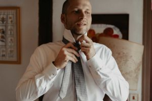 Le marié fait son nœud de cravate.