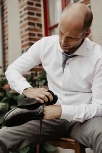 Le marié cire ses chaussures.