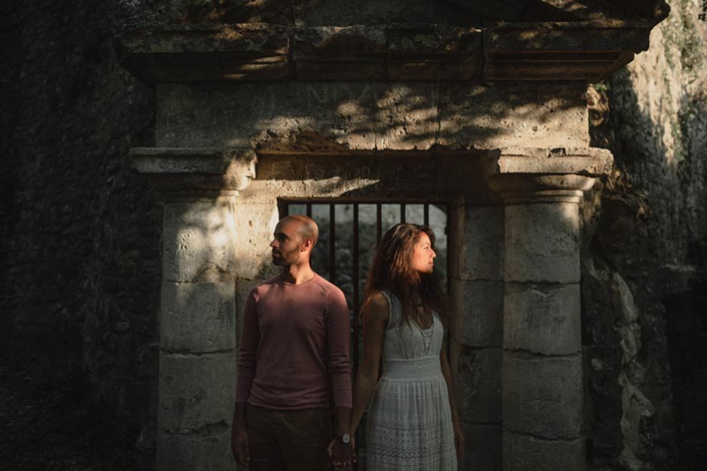 Un couple devant un édifice médiéval.