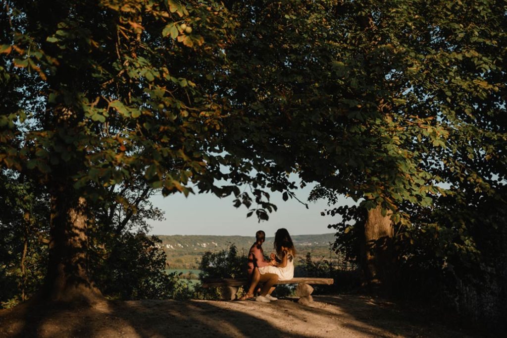 Un couple sur un banc sous les arbres.