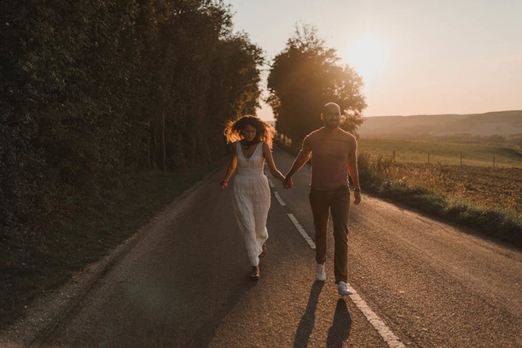 Un couple coure sur une route au coucher de soleil.