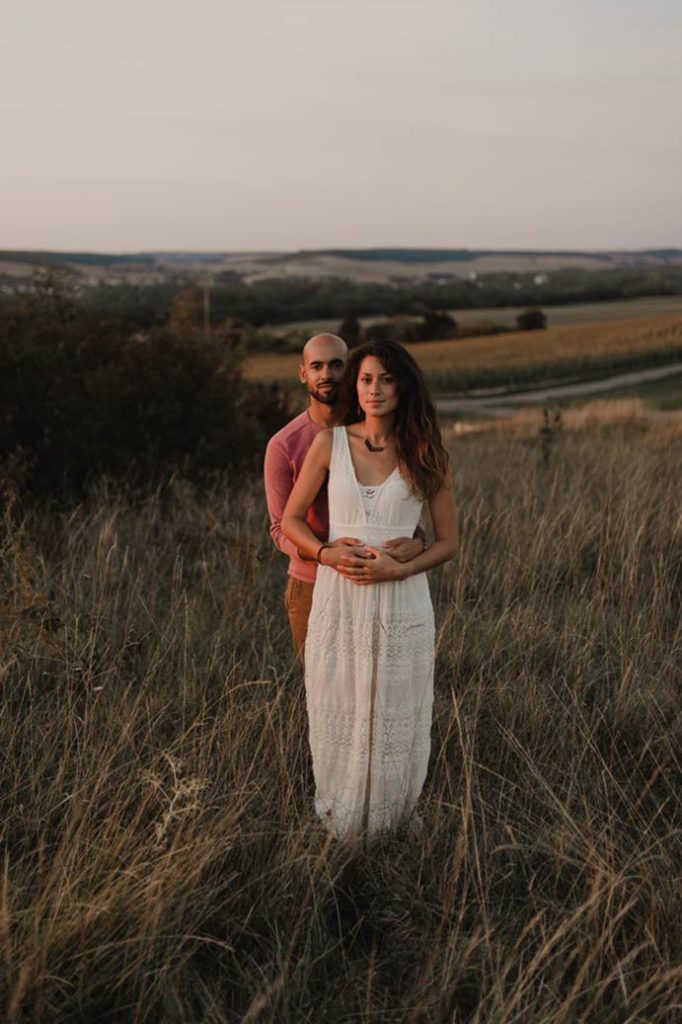 Couple dans les hautes herbes au soleil couchant.