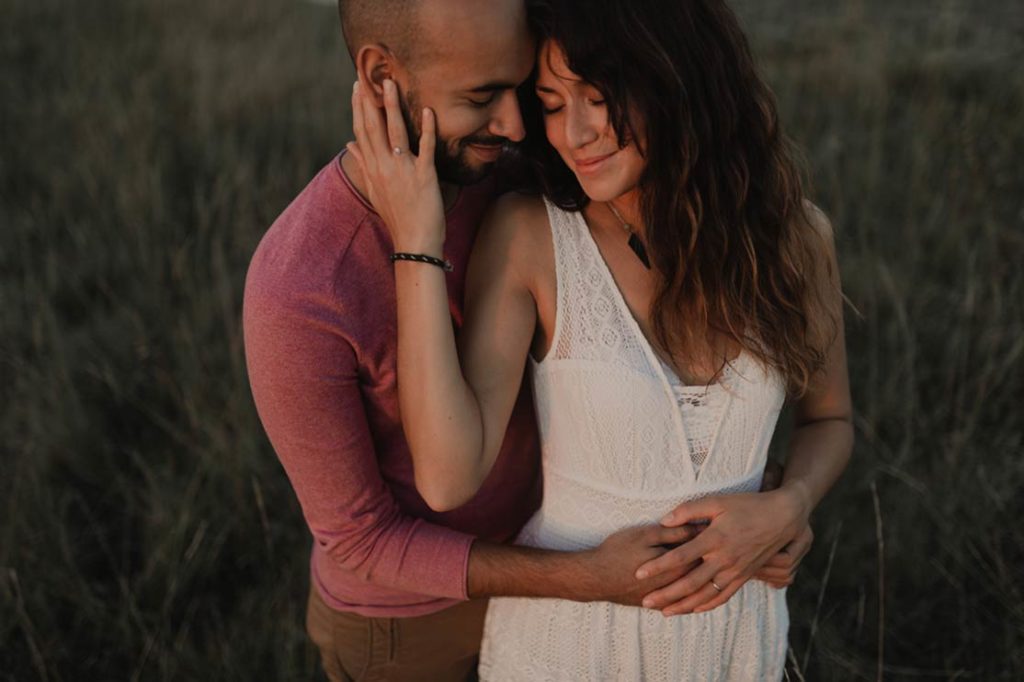 Couple heureux enlacé dans les hautes herbes.