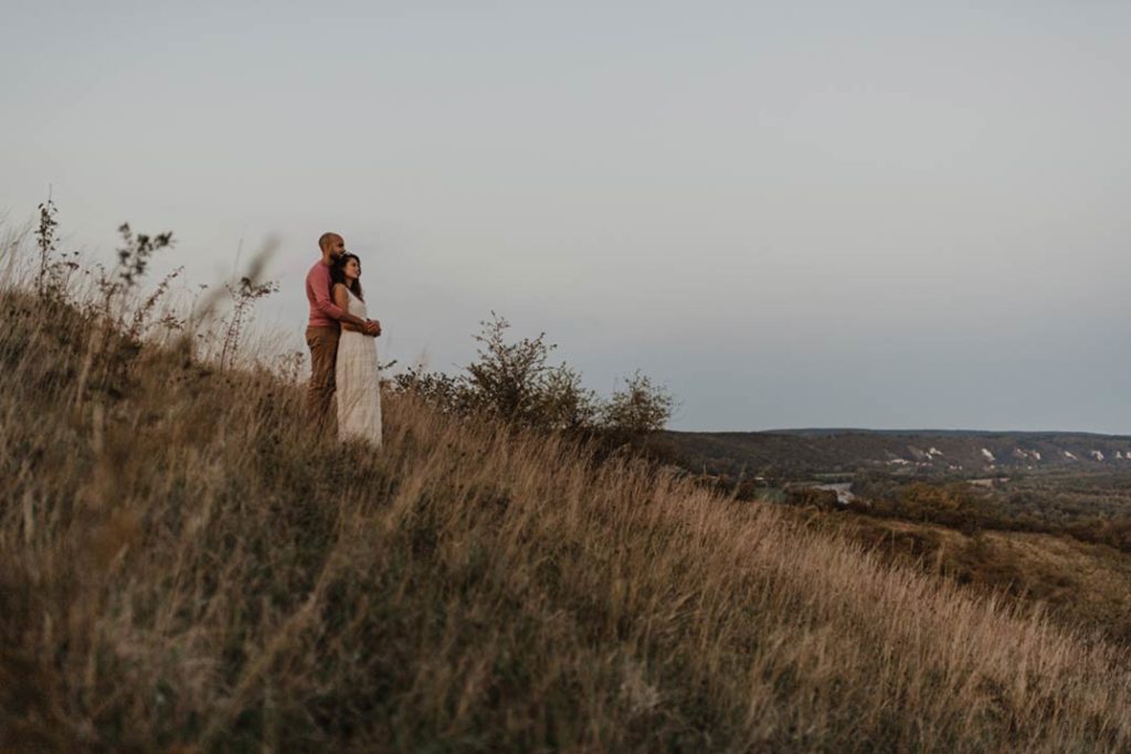 Couple enlacé face à une vallée.