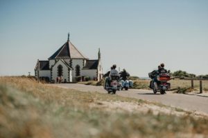 Motos roulant vers une chapelle.