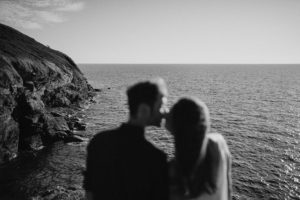 Couple qui s'embrasse devant l'océan.