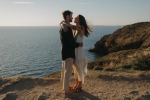 Couple enlacé devant l'océan.