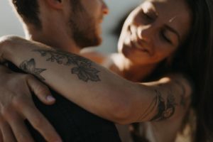 Couple qui s'enlace en bord de mer.