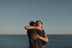Couple enlacé devant l'océan.