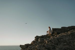 Couple assis sur les rochers en bord de mer.