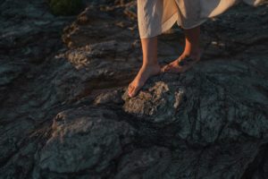 Pieds nus d'une femme qui marche sur les rochers.