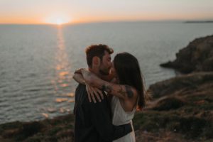 Couple qui s'embrasse en bord de mer.