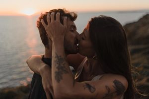 Couple qui s'embrasse sur le littoral au coucher dun soleil.