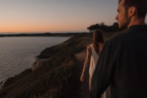 Couple sur le littoral à la tombée de la nuit.