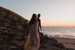Couple sur le rocher à la tombée de la nuit.