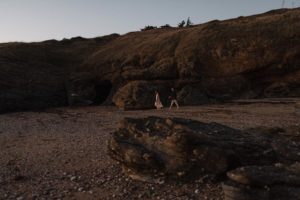 Couple sur une plage rocheuse.